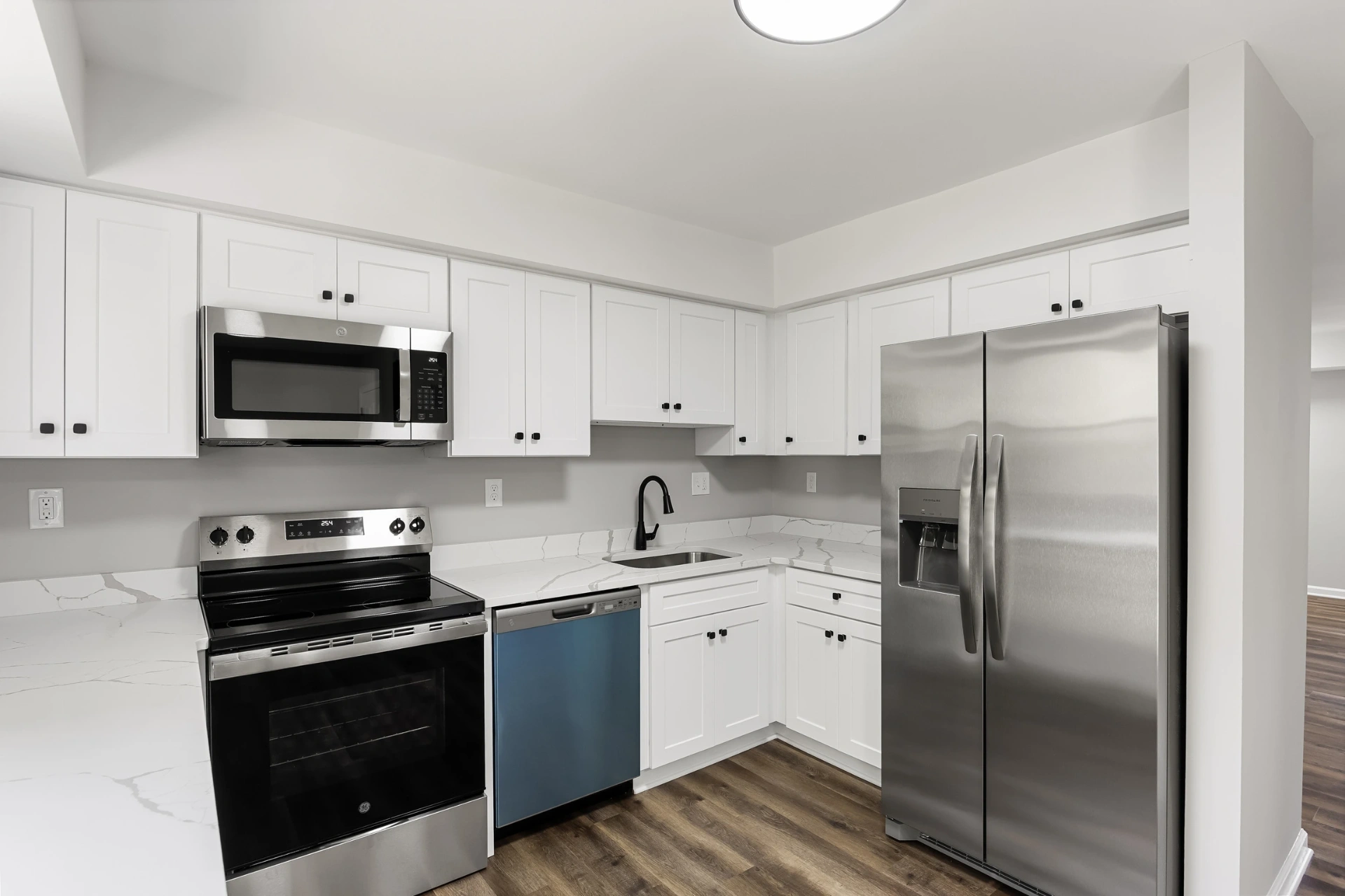 Bright white luxury kitchen with custom cabinetry and quartz counters, remodeled by A1 Brothers