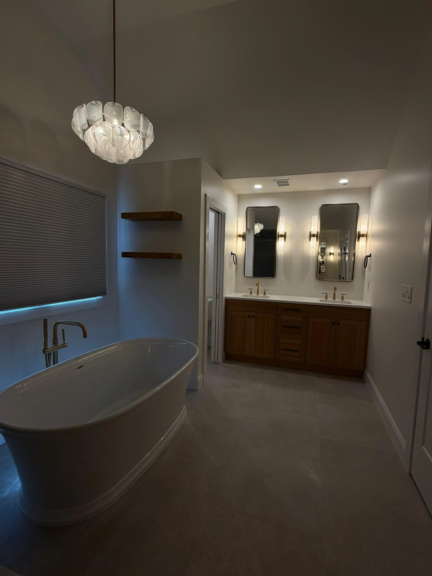Primary bathroom with a freestanding soaking tub and a double wood vanity