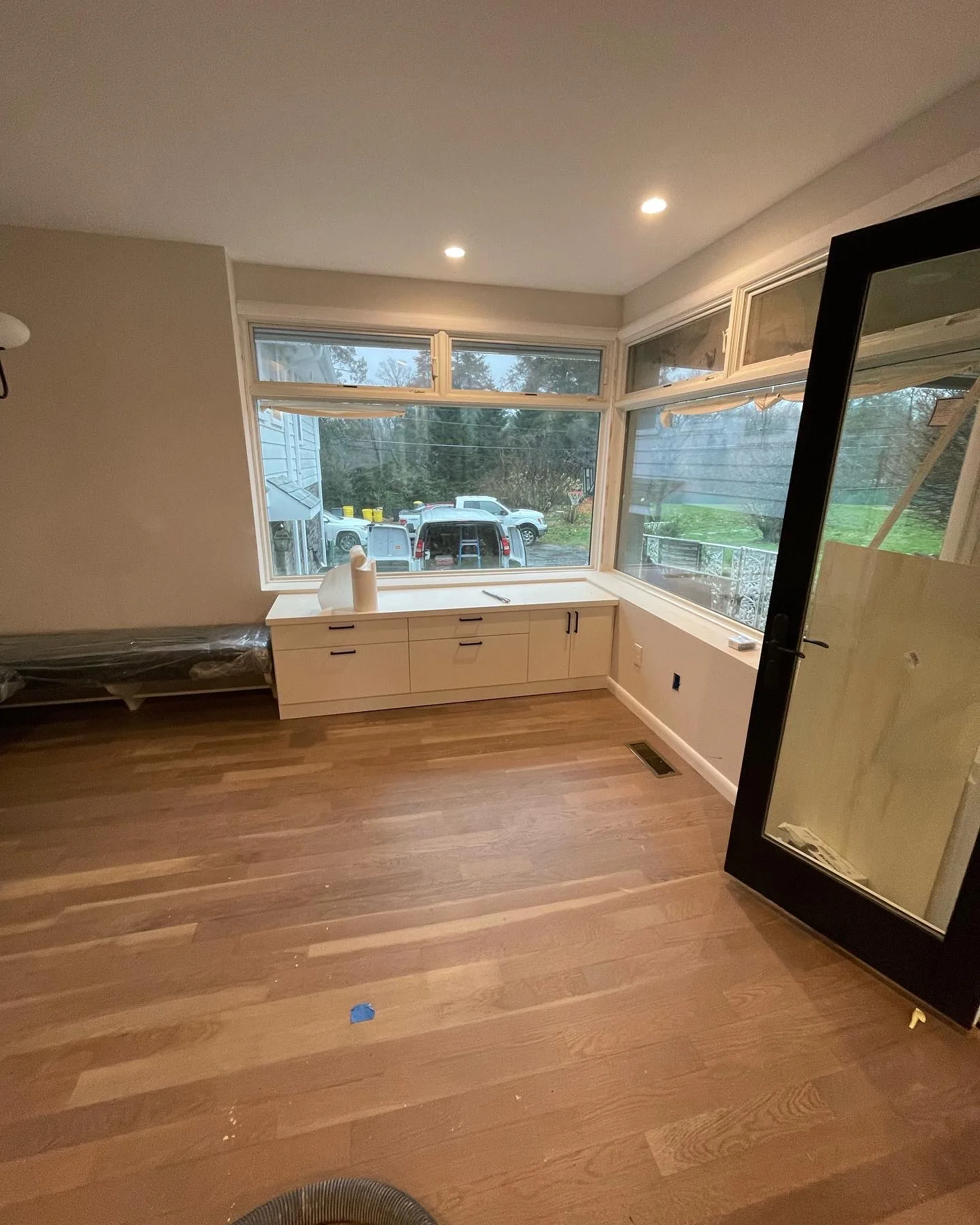 Custom window bench with built-in storage and wraparound picture windows by A1 Brothers